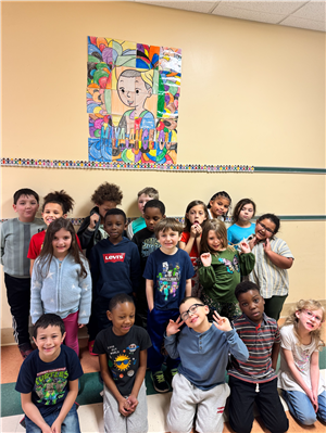 A group photo of students standing in front of a collection of coloring pages hung on a wall, arranged to form a bigger pic